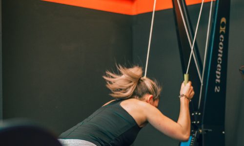 Sporter tijdens intensieve Hyrox groepstraining bij BBM Gym Maastricht, bezig met skierg