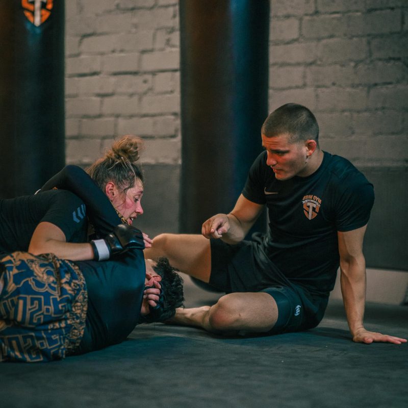 Trainer Ross die uitleg geeft aan duo tijdens MMA Maastricht